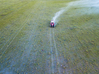 Overhead view of lime application in soil - Agricultural tractor used in tillage and pasture applying lime