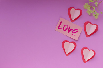 Red and pink hearts on a purple background. Valentin's Day, top view. 