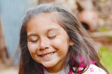 Happy latin kid with closed eyes.