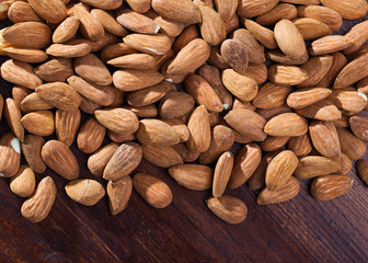 Obraz premium Roasted almonds on dark wood surface