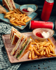 club sandwich with french fries on wooden board