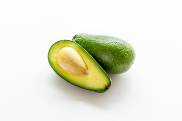 Avocado - ripe and bright, cutted in half - on white background closeup