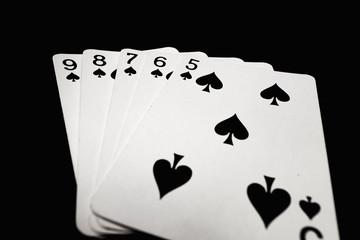 Straight flush of spades on black background