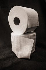 Stacked toilet Paper rolls on black background
