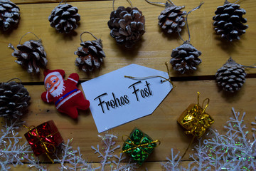 Frohes Fest write on label with wooden backgroud. It means Merry Christmas. Frame of Christmas Decoration.