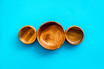 Making wooden dishes. Empty bowls on blue background top view copy space