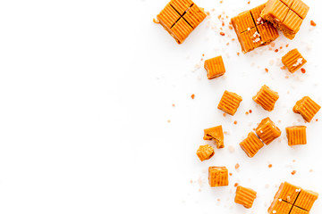 Salted caramel pieces - paradoxical sweets - on white background top view frame copy space