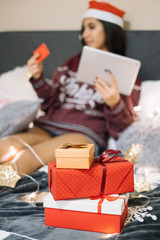 Wrapped Holiday presents with lights on bed