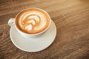 White coffee cup latte on wooden table in coffee shop, with empty space for text. Concept drink for relax .