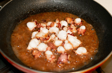 The process of frying chopped octopus on a hot pan