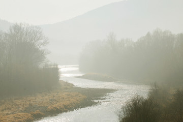 Fog visible in the riverbed. Autumn landscape