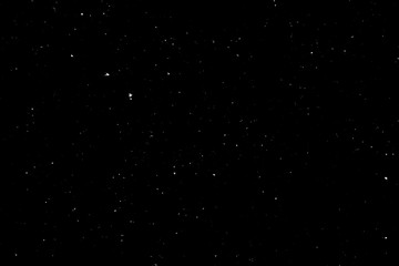 WHITE BOKEH ON A BLACK BACKGROUND. LIGHT SPOTS TEXTURE. FALLING SNOW. STAR SKY.