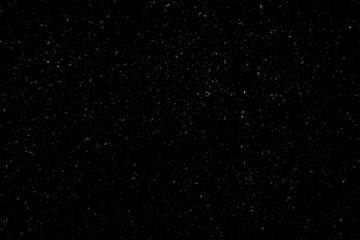 WHITE BOKEH ON A BLACK BACKGROUND. LIGHT SPOTS TEXTURE. FALLING SNOW. STAR SKY.