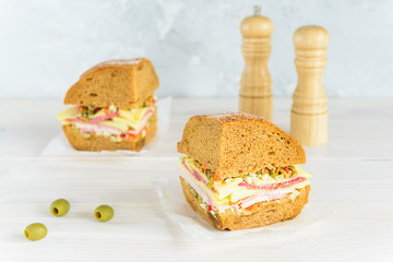 Sliced muffuletta sandwich on a wooden board.