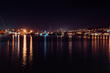 Fototapeta na wymiar Night view of port of Bodrum. Lights of the city and reflection in water, Bodrum, Turkey
