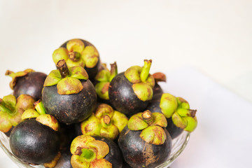 The purple mangosteen (Garcinia mangostana), known as the queen of fruits. Health benefits of mangosteen include a reduced risk of cancer, inflammation, allergies and diabetes.