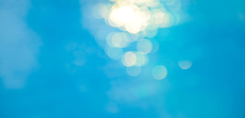 Bokeh light effects over a rippled, blue water background