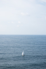 Fototapeta na wymiar Solitude boat sailing in ocean in summer