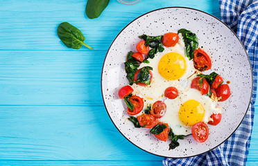 Breakfast. Ketogenic diet food. Fried egg, spinach, and tomatoes. Keto, paleo breakfast. Top view, copy space