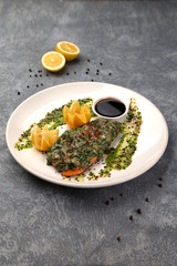 fried salmon topped with herbs and sauce