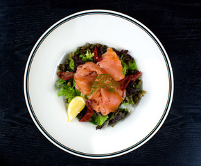 vegetable salad topped with smoked salmon