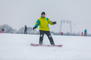 man snowboarding down by hill
