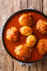 Ethiopian food Doro Wat of chicken with eggs in a spicy sauce close-up in a plate. Vertical top view