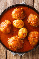 Ethiopian stew Doro Wat from chicken with eggs and spices close-up in a plate. Vertical top view