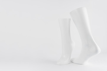 Abstract white modern statuette of two elegant white dancing legs on white background with copy space.