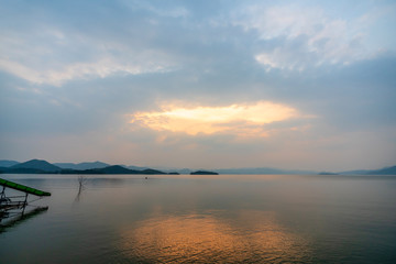 Naklejka premium beautiful blue sky green forest mountains lake view at Kaeng Krachan National Park, Thailand. an idea for backpacker hiking on long weekend or a couple, family holiday activity camping relaxing