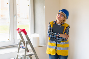 Woman Builder in the room of the house making repairs.