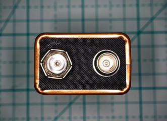  Top view of a nine volts battery type on a geometric background. Macro image