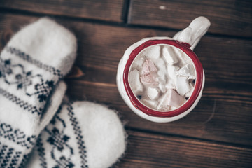 Fototapeta premium Christmas scene with mittens and hot chocolate with marshmallow
