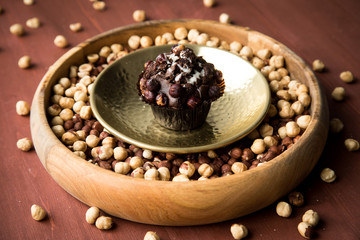 Haselnuss Muffin in Gold Messing Metall und Holz Schale mit Nüsse auf Holz Tisch Hintergrund