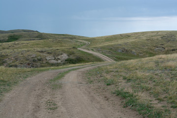 Green, grassy hill. The path, the road on the hill. Summer season. Nature "Kapa"l. Cloudy weather. Mountains "Alatau".