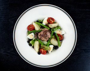 vegetable salad topped with meat and sliced eggs