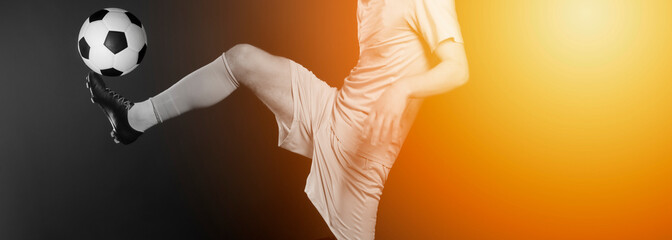 Close up legs and soccer shoe of football player in action kicking ball isolated on black...