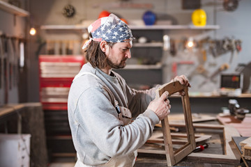 Carpenter working on the old wood in a retro vintage workshop.
