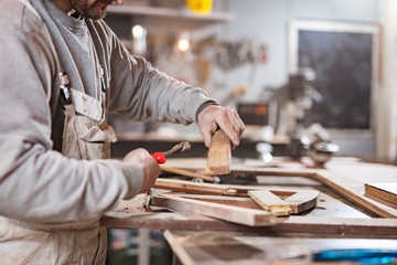 Carpenter working on a old wood in a retro vintage workshop.