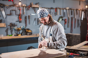 Carpenter working on a old wood in a retro vintage workshop.