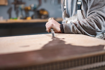 Carpenter working on a old wood in a retro vintage workshop.