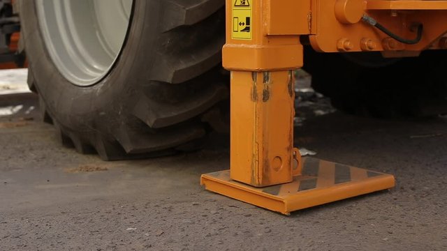 Folding the hydraulic stop in the tractor excavator after completion of work, close-up