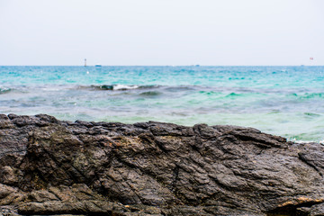 The rocks on the beach and the incoming sea water. And the sea and sky background