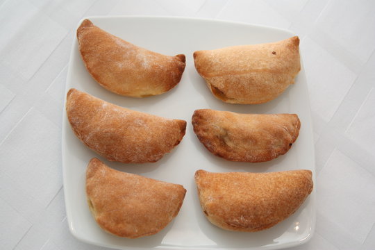 Chicken pies in a white plate on the table, top view 