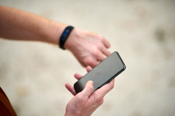 Man using cellphone in urban area at summer time.
