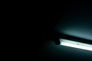 Opened LED light tube on dark background. LED fluorescent lamp light. Lighting equipment. Lamp...