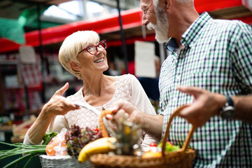 Senior family couple choosing bio food fruit and vegetable on the market during weekly shopping