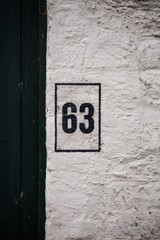 black number 63 on white wall