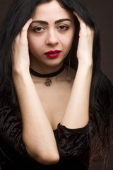 brunette on dark background dressed in goth style