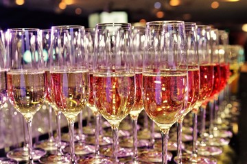 Rows of full champagne, sparkling wine and red wine glasses. Dining, drink. Catering service concept.
